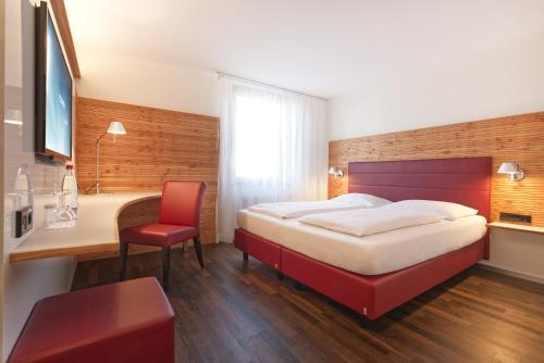 a bedroom with a bed and a desk and a chair at Parkhotel Schillerhöhe in Marbach am Neckar