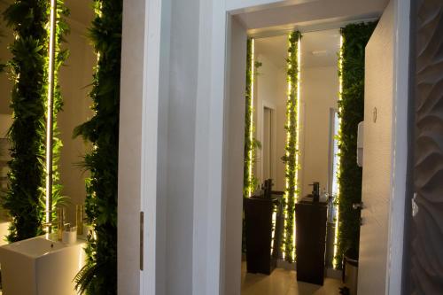 a hallway with mirrors with plants and lights at Cincis by the Lake in Cinciş