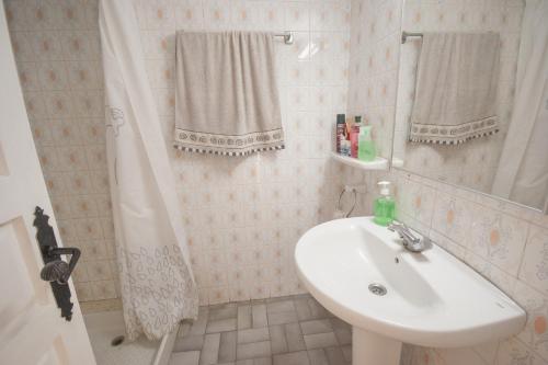 uma casa de banho branca com um lavatório e um chuveiro em 1 Med 17 - Pals em Pals