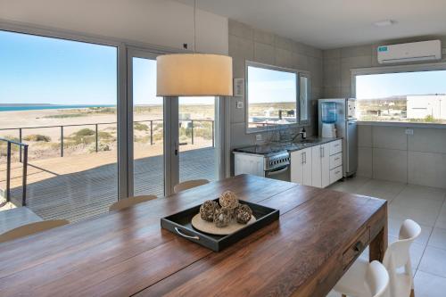 eine Küche mit einem Tisch und Strandblick in der Unterkunft CASA 360 - Hermosa casa de playa en Chocón Medio 