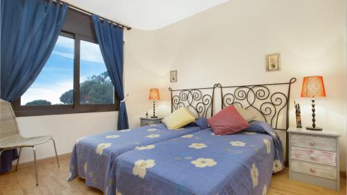 1 dormitorio con 1 cama con edredón azul y ventana en 2 Moni - Lloret de Mar, en Lloret de Mar