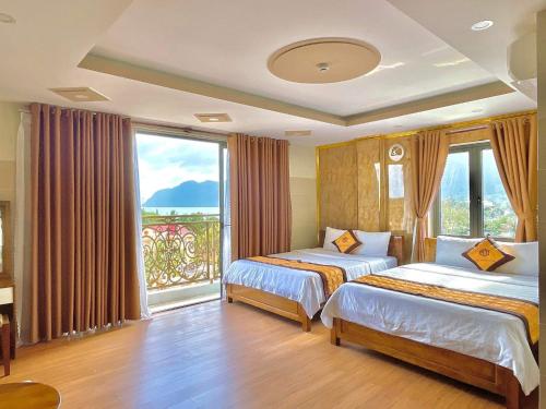 a hotel room with two beds and a large window at Hotel Minh Thắng 2 in Con Dao
