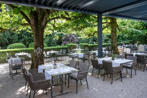a group of tables and chairs under a tree at Romantik Hotel & Restaurant Sternen in Kriegstetten