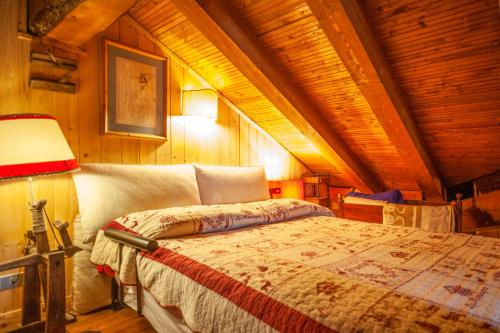 sypialnia z łóżkiem w drewnianym suficie w obiekcie Spacious chalet low-cost for a group holiday w mieście Courmayeur