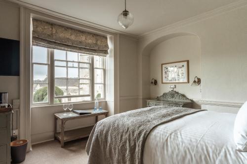 1 dormitorio con cama y ventana en The Falcon Inn en Painswick