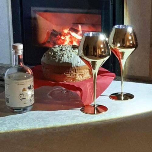 dos copas de vino sentadas en una mesa con chimenea en Bed and Breakfast Isabella, en Miane
