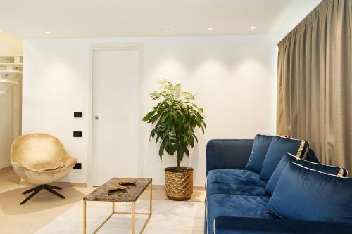 a living room with a blue couch and a plant at Palazzo Salomone in Siracusa