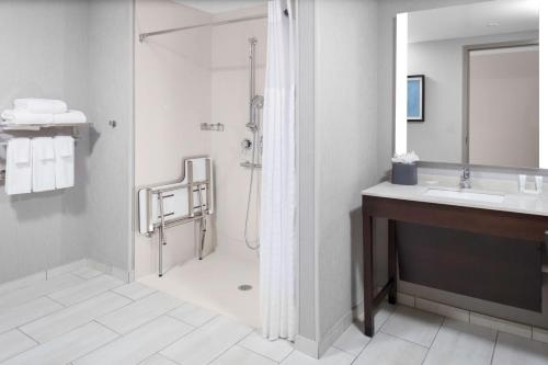 a bathroom with a shower and a sink at Hyatt Place Charlotte University in Charlotte