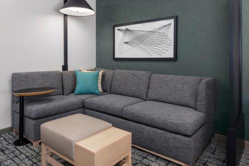 a living room with a gray couch and a table at Hyatt Place Charlotte University in Charlotte