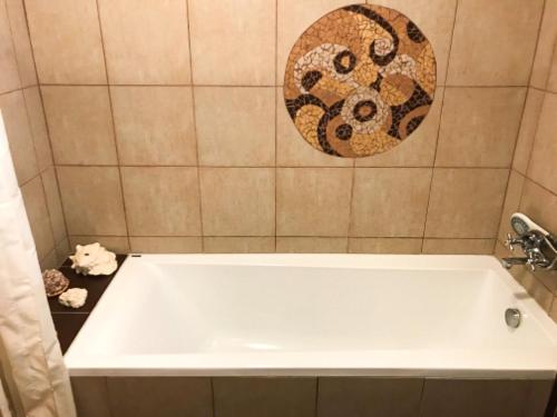 a white bath tub in a bathroom with a tile wall at Penzion Domanín in Třeboň