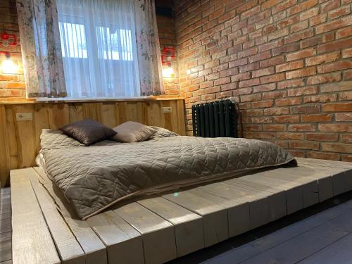 a bed in a room with a brick wall at BrickWood in Verkhniy Koropets