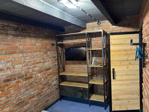 a brick wall with a wooden shelf in a room at BrickWood in Verkhniy Koropets