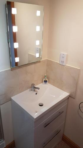 a bathroom with a white sink and a mirror at Modern 1 bed Apartment close to Campbeltown in Campbeltown