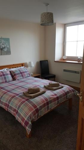 a bedroom with a bed with two pillows on it at Modern 1 bed Apartment close to Campbeltown in Campbeltown