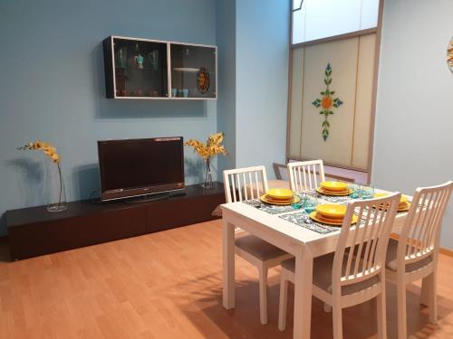 a dining room with a table with chairs and a tv at Juliette Rooms in Iesi