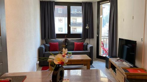 - un salon avec un canapé et une table dans l'établissement Chamois de Chamonix, Confortable 2 pièces, balcon, parking gratuit, à Chamonix-Mont-Blanc