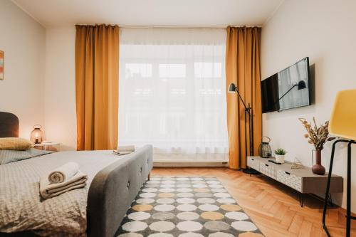 um quarto com uma cama e uma grande janela em Elegant studio, 400m from the square em Plzeň