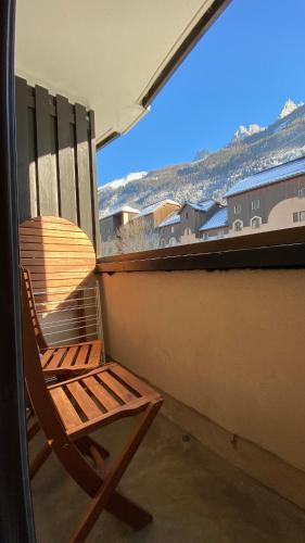 a wooden chair sitting on a balcony with a window at Chamois de Chamonix, Confortable 2 pièces, balcon, parking gratuit in Chamonix-Mont-Blanc