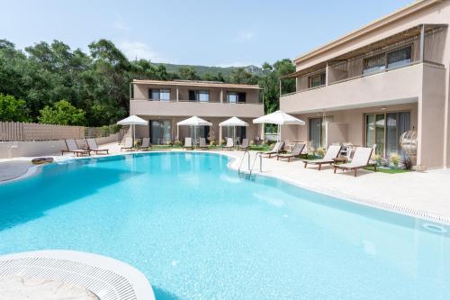 a swimming pool in front of a house at Scarabeo Suites & Villas Parga in Parga