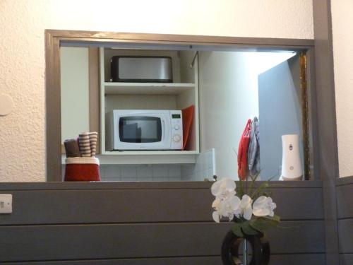 a mirror in a bathroom with a microwave at Chamois de Chamonix, Confortable 2 pièces, balcon, parking gratuit in Chamonix-Mont-Blanc