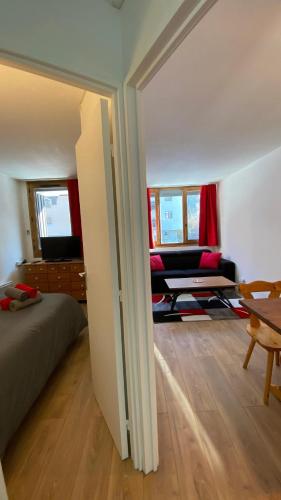 a bedroom with a bed and a living room with a couch at Chamois de Chamonix, Confortable 2 pièces, balcon, parking gratuit in Chamonix-Mont-Blanc