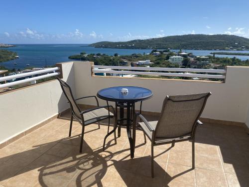 einen Tisch und Stühle auf einem Balkon mit Blick auf das Wasser in der Unterkunft Ulala Culebra in Culebra