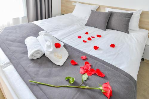 a bed with red roses and towels on it at Lubhotel in Lublin