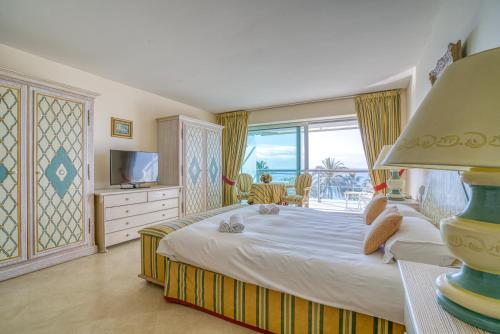 une chambre avec un grand lit et une télévision dans l'établissement Apartment 60sqm Croisette - Balcony with sea view, à Cannes