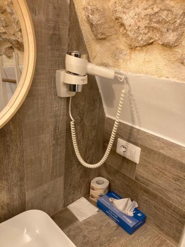 a bathroom with a toilet with a phone on the wall at Pietrabianca Santa Maria Apartments in Manfredonia