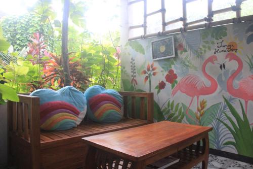a room with a bench with pillows and a table at Summer Homestay Bali in Nusa Dua