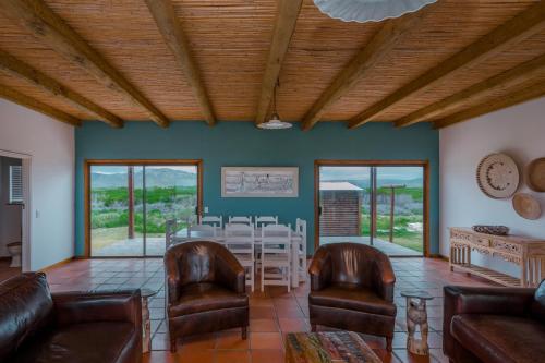 a living room with a table and chairs at The Log House in Pearly Beach