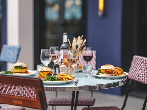 a table with plates of food and glasses of wine at Eklo Toulouse in Toulouse