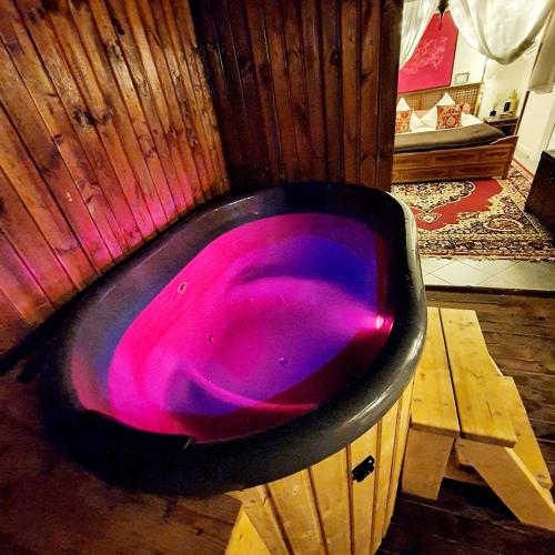 d'une baignoire noire avec un liquide rose. dans l'établissement L'écrin de Rûmi, à Vaires-sur-Marne