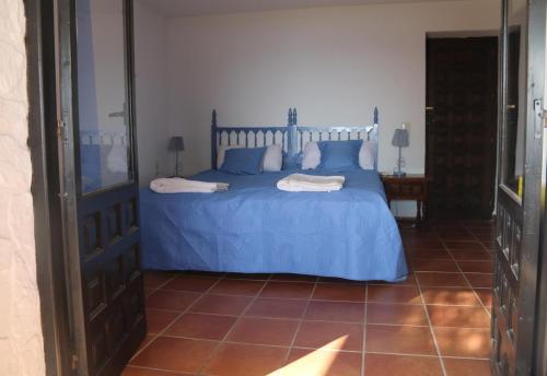 a bedroom with a blue bed with a blue comforter at Villa Las Dalias in Almuñécar