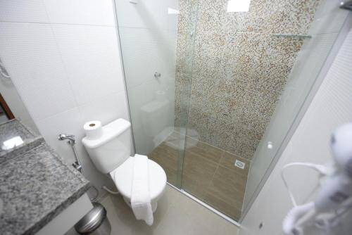 a bathroom with a toilet and a glass shower at Hotel Leon in Barbalha