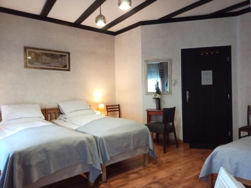 a room with two beds and a black door at Avalon Rooms in Oradea