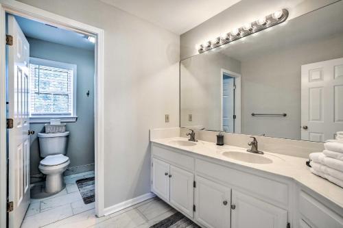 a bathroom with two sinks and a toilet at Deck and Yard Family-Friendly Lawrenceville Home! in Lawrenceville