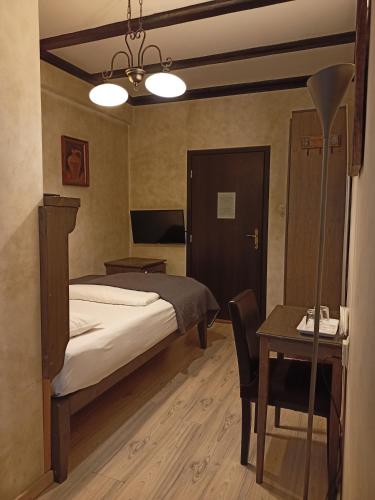 a bedroom with a bed and a desk and a table at Avalon Rooms in Oradea