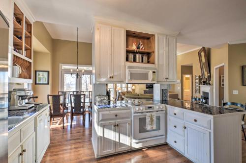 a kitchen with white cabinets and a stove top oven at Lavonia Lake House with Private Dock and Bonfire! in Lavonia