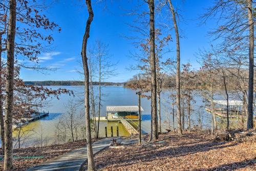a house on a dock on a lake with trees at Lavonia Lake House with Private Dock and Bonfire! in Lavonia