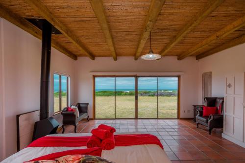 a bedroom with a bed and views of a field at The Log House in Pearly Beach