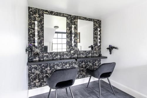 a bathroom with two chairs and a mirror at Historic country house retreat with indoor swimming pool and hot tub, ideal for large groups in Petty France