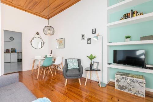 a living room with a table and chairs and a tv at Baixa Heritage Apartments by Cathedral & Tram 28 by NestAtLisbon in Lisbon