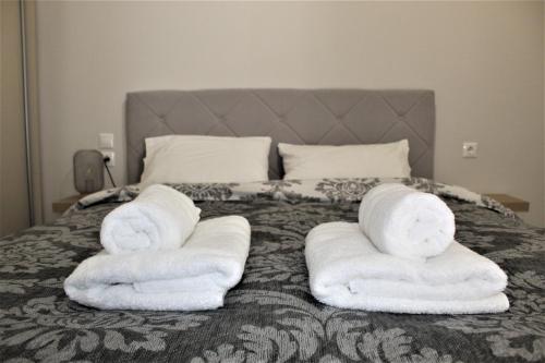 Una cama con toallas plegadas encima. en Khibra 1, en Volos
