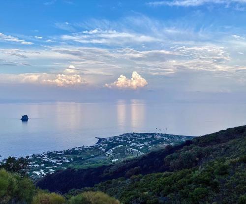 a large body of water with a town on a hill at Stromboli Suite Apartment with Terrace Volcano & Sea view in Stromboli