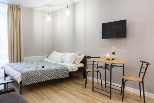 a small hotel room with a bed and a table at Naykova district Apartments in Kharkiv