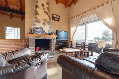 a living room with a couch and a fireplace at Casa Xixella a 15 min de Sitges in Olivella