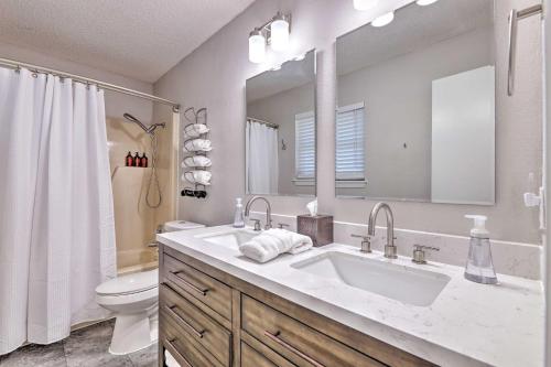 a bathroom with a sink and a toilet and a mirror at Modern Fayetteville Home Less Than 1 Mi to U of A! in Fayetteville