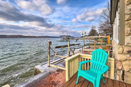 a pair of blue chairs sitting on a dock next to the water at Lakefront Canandaigua Home with Grill, Fire Pit in Canandaigua