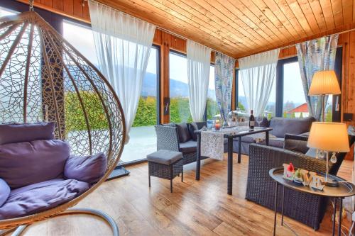 a living room with a hanging swing and a table and chairs at Osada Kotarz in Brenna
